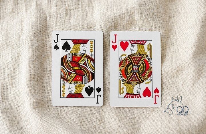本色亚麻布上两张正面朝上的牌：黑桃 J 与红桃 J 一对